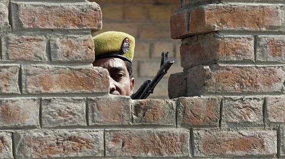 An trooper keeps guard from a bunker after a grenade blast in a market in Srinagar