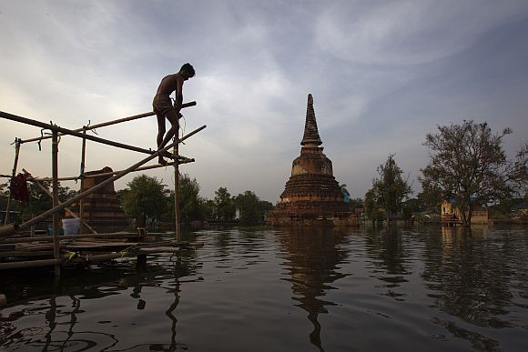A resident builds a temporary shelter to escape flood waters near Wat Hasadawat temple in Thailand's ancient capital Ayutthaya.