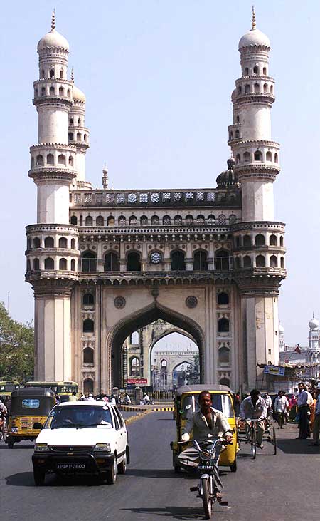Residents of Hyderabad drive past the 'Charminar', the city's best known monument