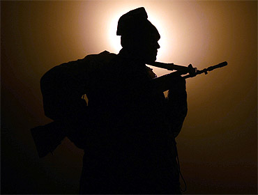A BSF soldier patrols near the fencing at the India-Pakistan border