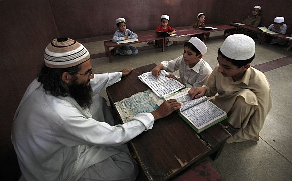A teacher guides students in reciting verses from the Holy Koran at a mosque in Peshawar.