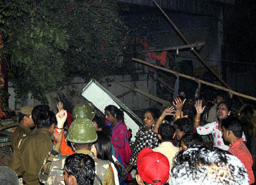 People at the site of the fire that broke out during a congregation of eunuchs at a community center in New Delhi