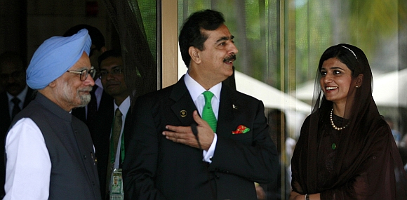 Pakistan's Prime Minister Yusuf Raza Gilani gestures as his Indian counterpart Manmohan Singh and Pakistan's Foreign Minister Hina Rabbani Khar watch during their joint news conference on the sidelines of the 17th South Asian Association for Regional Cooperation