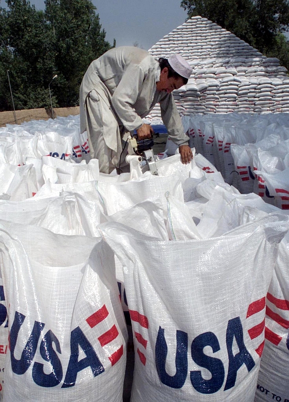 An worker arranges bags of wheat at the United Nations World Food Programme store in Peshawar