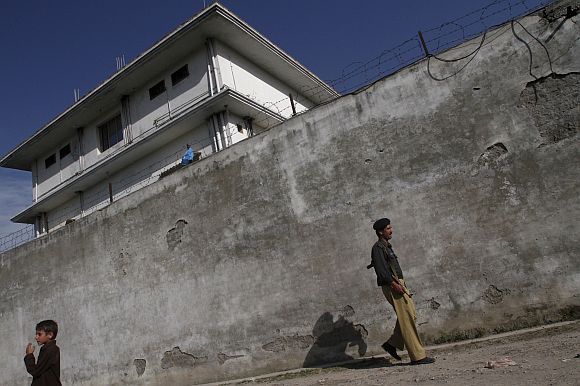 A Pakistani policeman walks in front of the compound where Al Qaeda leader Osama bin Laden was killed in Abbottabad