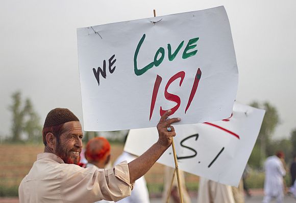 An activist holds a placard as protesters rally in favour of Pakistan's army and Inter-Services Intelligence in Islamabad