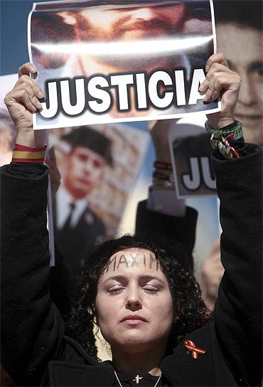 The daughter of a victim of the Basque separatist guerrilla group ETA holds her father's picture during a demonstration in Madrid