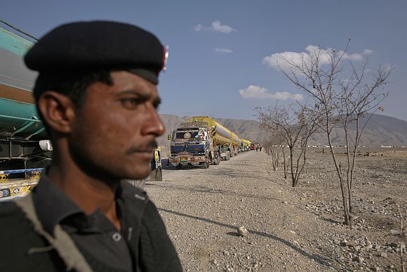 A policeman stands guard near trucks, some of which were carrying supplies to NATO forces in Afghanistan, as they line up in the outskirts of Quetta