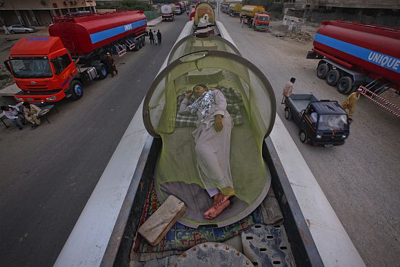 Drivers, some of whom were carrying fuel for NATO forces in Afghanistan, sleep on top of their trucks at a fuel terminal in Karachi