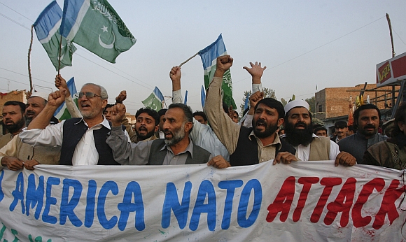 Supporters of religious political party Jamaat-e-Islami hold a banner while demonstrating against NATO