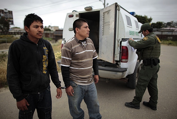 A United States border patrol agent catches illegal immigrants crossing from Mexico to the U S in San Ysidro, California,