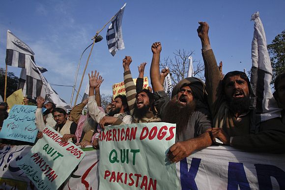 Supporters of Jamaat-ud-Dawa hold placards while shouting ant-American slogans during a demonstration in Lahore on Tuesday