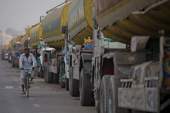 A man rides his bicycle past tankers, carrying fuel for NATO forces, lined up along a road in Karachi, after traffic was halted at the Pakistan-Afghanistan border.