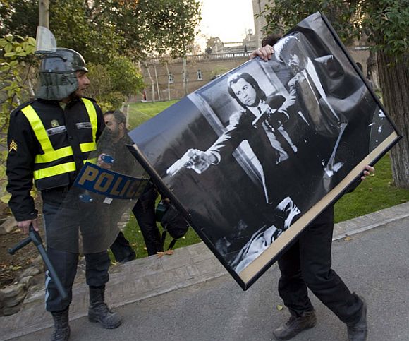 A protester walks away from the embassy with a Pulp Fiction poster