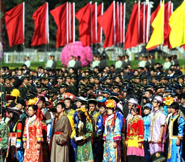 People in traditional attire take part in a National Day ceremony before the Monument to the People's Heroes at Tiananmen Square in Beijing