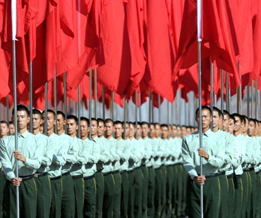 Participants hold red flags during the National Day ceremony at Tiananmen Square in Beijing