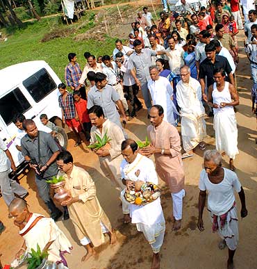 Villagers and family members accompany Pranab Mukherjee to a canal of the Kueye river to perfom a ritual