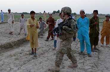 Afghan boys greet a US female soldier from Task Force Bronco 3rd Platoon 307th MP Company while patrolling in a village in Shinwar district in Nangarhar, in this picture taken on September 10, 2011.