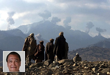 Anti-Taliban Afghan fighters watch several explosions from US bombings in the Tora Bora mountains in Afghanistan in this picture taken on December 16, 2001. (inset) Eric De Castro.