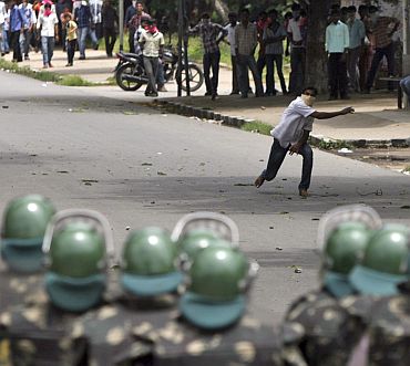 A pro-Telangana demonstrator throws a stone towards riot police during a protest in Hyderabad