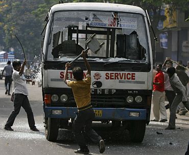 Pro-Telangana activists damage a passenger bus during a protest in Hyderabad