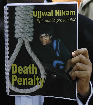 Special Prosecutor Ujjwal Nikam holds up a document with a cover of Kasab