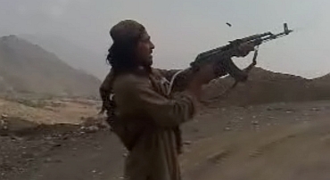 A Pakistan Taliban fires a weapon in the air