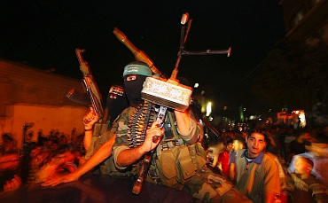 Palestinian Hamas militants take part in a rally as they celebrate news of a prisoner swap, in Jabalya in the northern Gaza Strip October
