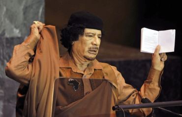 Muammar Gaddafi holds a Charter of the United Nations and Statute of the International Court of Justice as he addresses the 64th United Nations General Assembly at the U.N