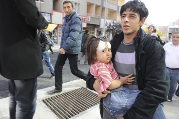 A man carries an injured girl after an earthquake in Tabanli village near the eastern Turkish city of Van