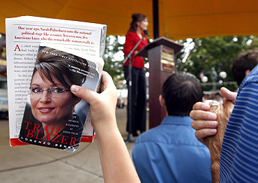 A supporter holds up books by former Alaska governor Sarah Palin for autographs