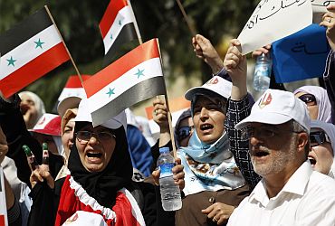 Syrian opposition demonstrators wave their national flags during a protest