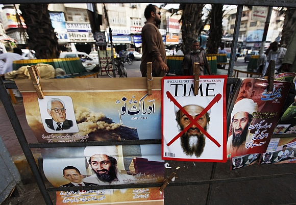 A newspaper stand displays magazines and posters bearing the pictures of Al Qaeda leader Osama bin Laden and Obama