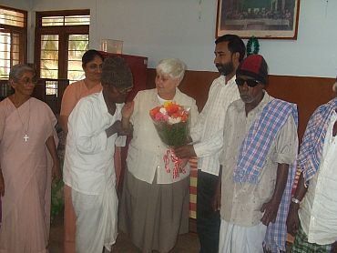 Father George, director of the Sumanahalli Society, presents a bouquet to Sister Jean