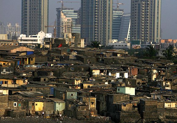 High rise residential buildings are seen behind a slum in Mumbai