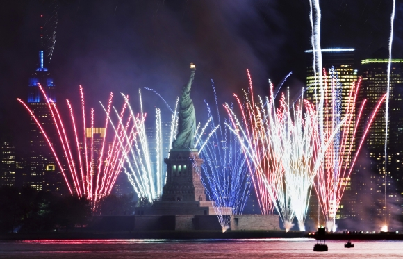 Fireworks go off in New York Harbor to celebrate the 125th birthday of the Statue of Liberty