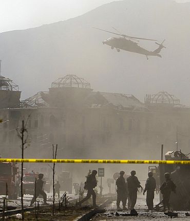 A NATO helicopter flies over the site of a bomb blast in Kabul on October 29