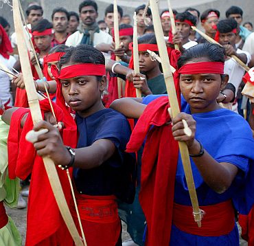 Tribals supporting Naxal ideology pose with bows and arrows during a rally in Kolkata