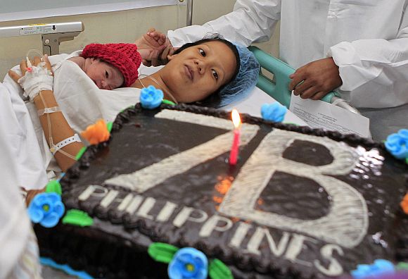 United Nations Population Fund staff gives a cake to the family of newborn baby girl named Danica Camacho