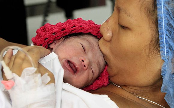 Filipina mother Camille kisses her newborn baby girl named Danica Camacho