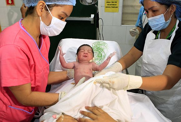 Midwives hold the newborn baby girl named Danica Camacho