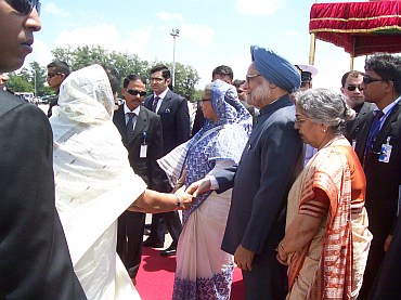 Bangladesh's Prime Minister Hasina greets Dr Manmohan Singh and his wife Gursharan Kaur upon their arrival in Hazrat Shahjalal International Airport in Dhaka