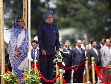 Indian PM Singh and Hasina review an honour guard at Hazrat Shahjalal International Airport in Dhaka