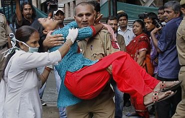 A nurse tries to assist as a policeman carries a woman, who was injured by a blast outside the high court
