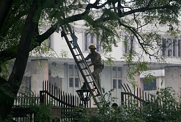 A police officer looks for evidence at the site of a bomb blast outside the Delhi HC