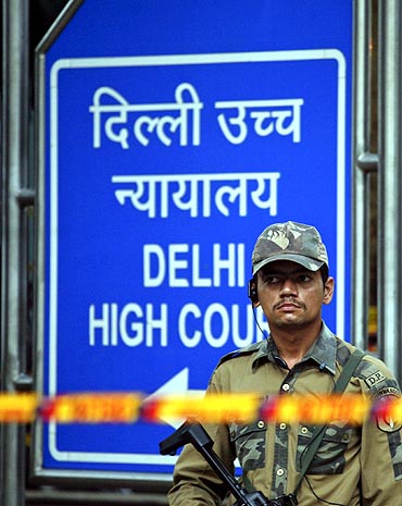 A police commando stands guard outside Delhi high court after Wednesday's bomb blast