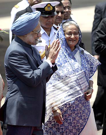 Prime Minister Manmohan Singh greets as Bangladesh's Prime Minister Sheikh Hasina watches after they arrive in Dhaka on September 6.