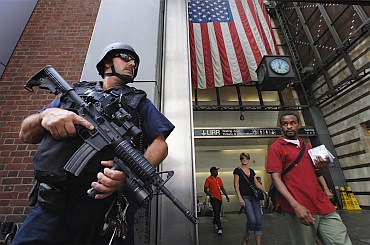 Members of the public react as they walk past a NYPD Hercules team on patrol near Penn Station in New York