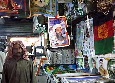 A man walks past a poster of slain Al Qaeda leader Osama bin Laden on display for sale