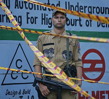 A SWAT member of the Delhi police force stands guard outside the high court after Wednesday's bomb blast